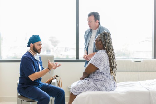 Image shows a surgeon speaking with a patient